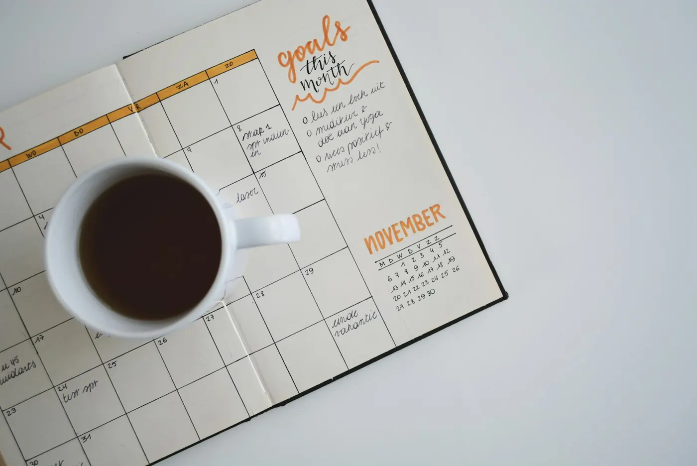 Agenda mensual abierta con café — pensar en décadas, no en el descuento de hoy