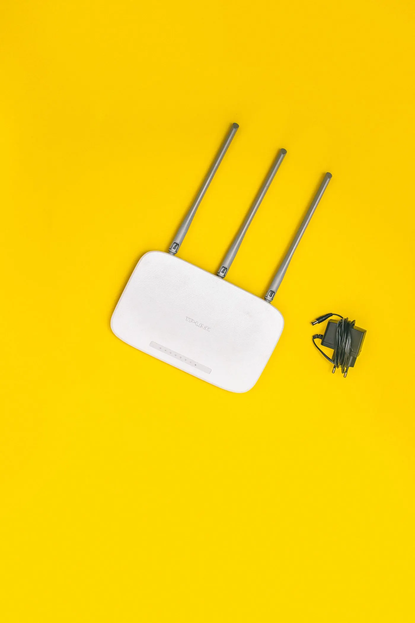 Router Wi-Fi doméstico sobre fondo amarillo